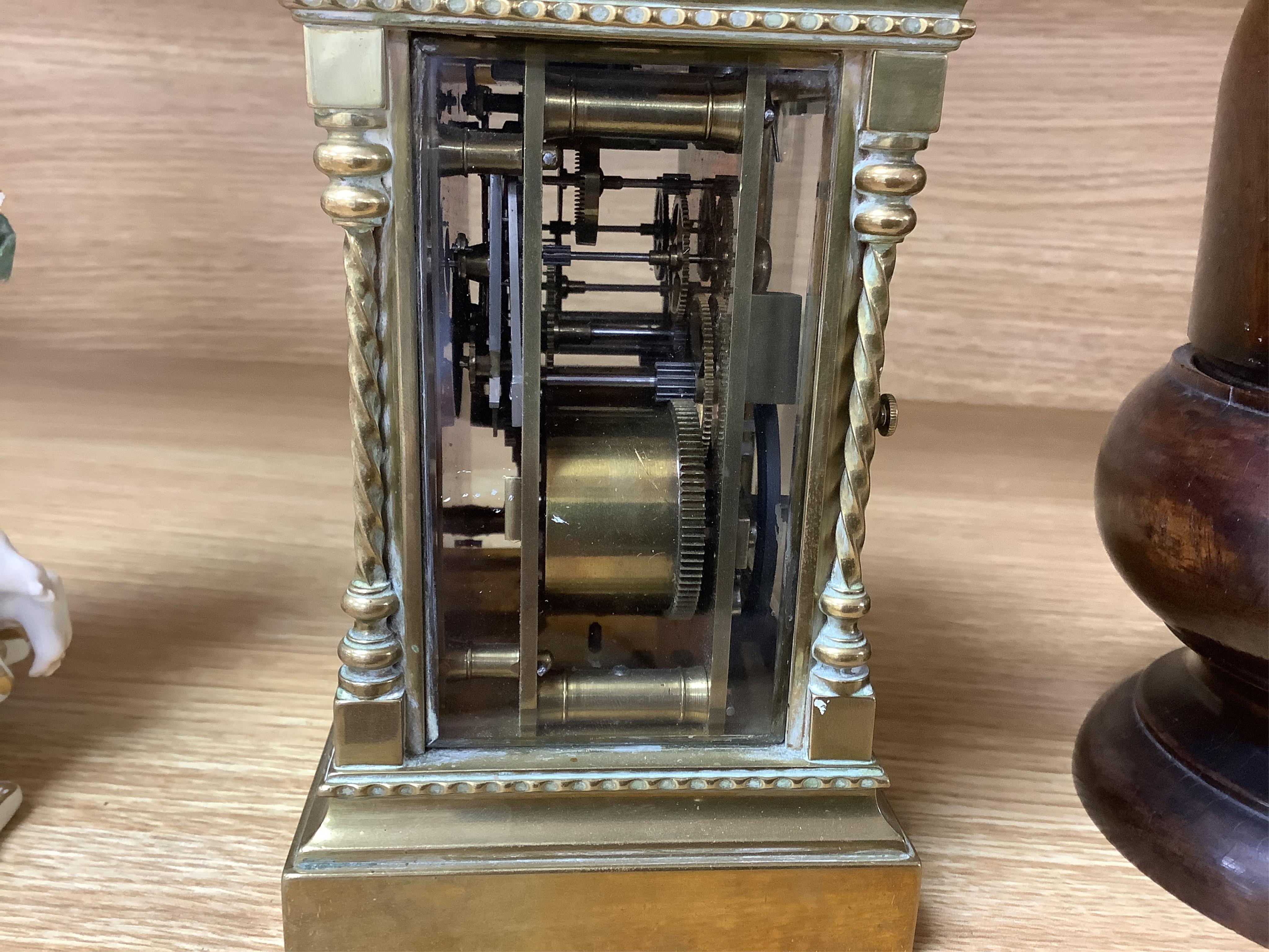 A large brass repeating carriage clock with key and ornate filigree dial, 17cm high (including handle). Condition - good, unchecked if working